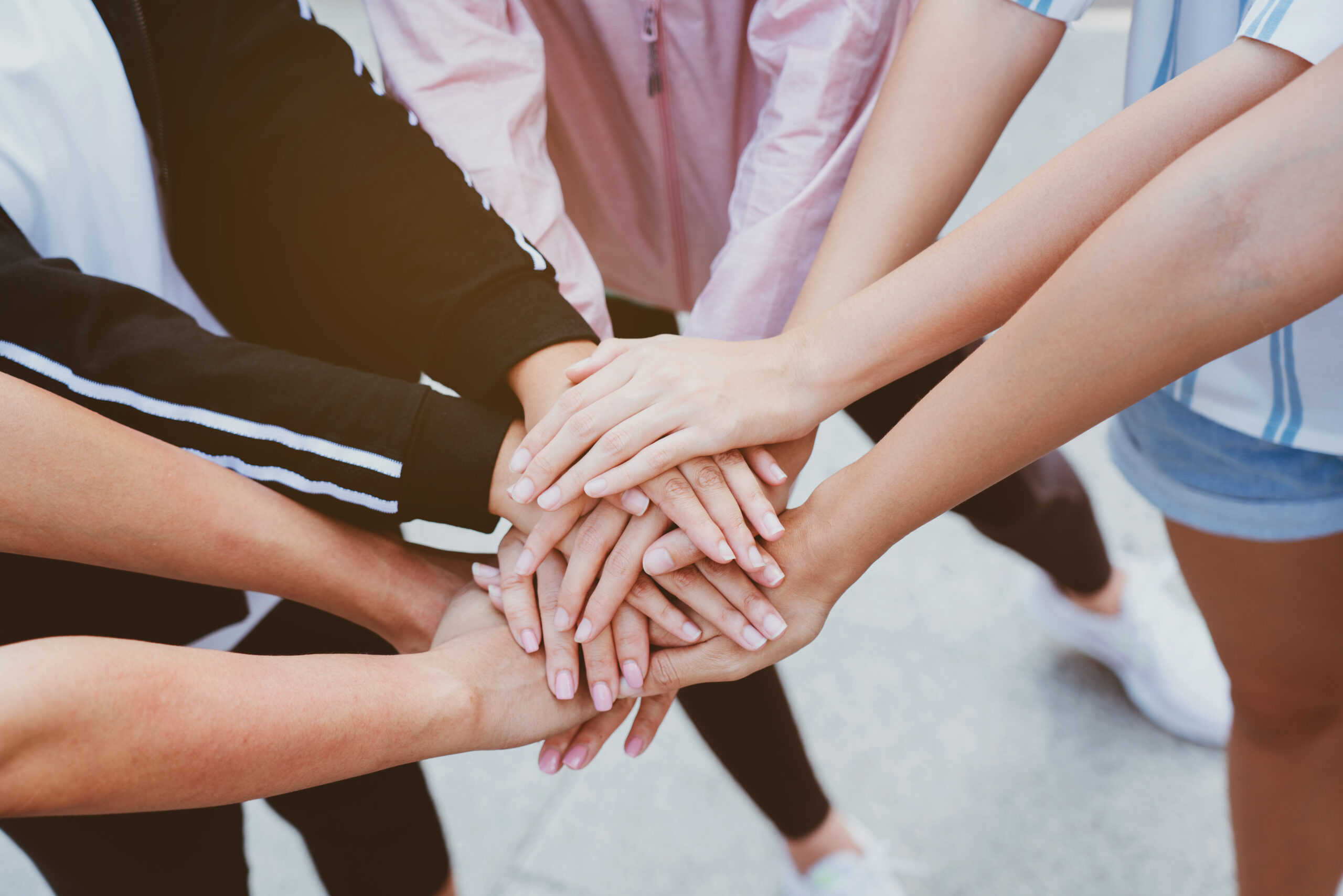 Close up at the hands many teenage girls. Show unity as a collaborative work together. To succeed, one has to understand each other in communication. Concept International Women's Day